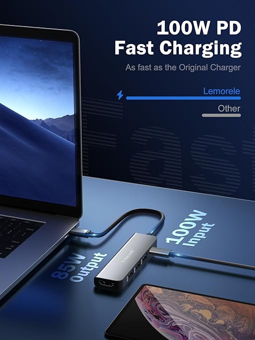 Laptop with USB-C adapter and phone on a blue surface, highlighting 100W PD fast charging.