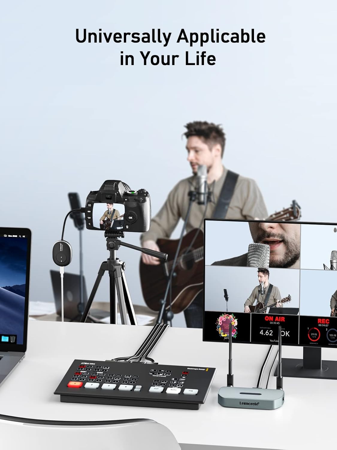 Person recording a video with audio equipment on a desk, surrounded by multiple screens.