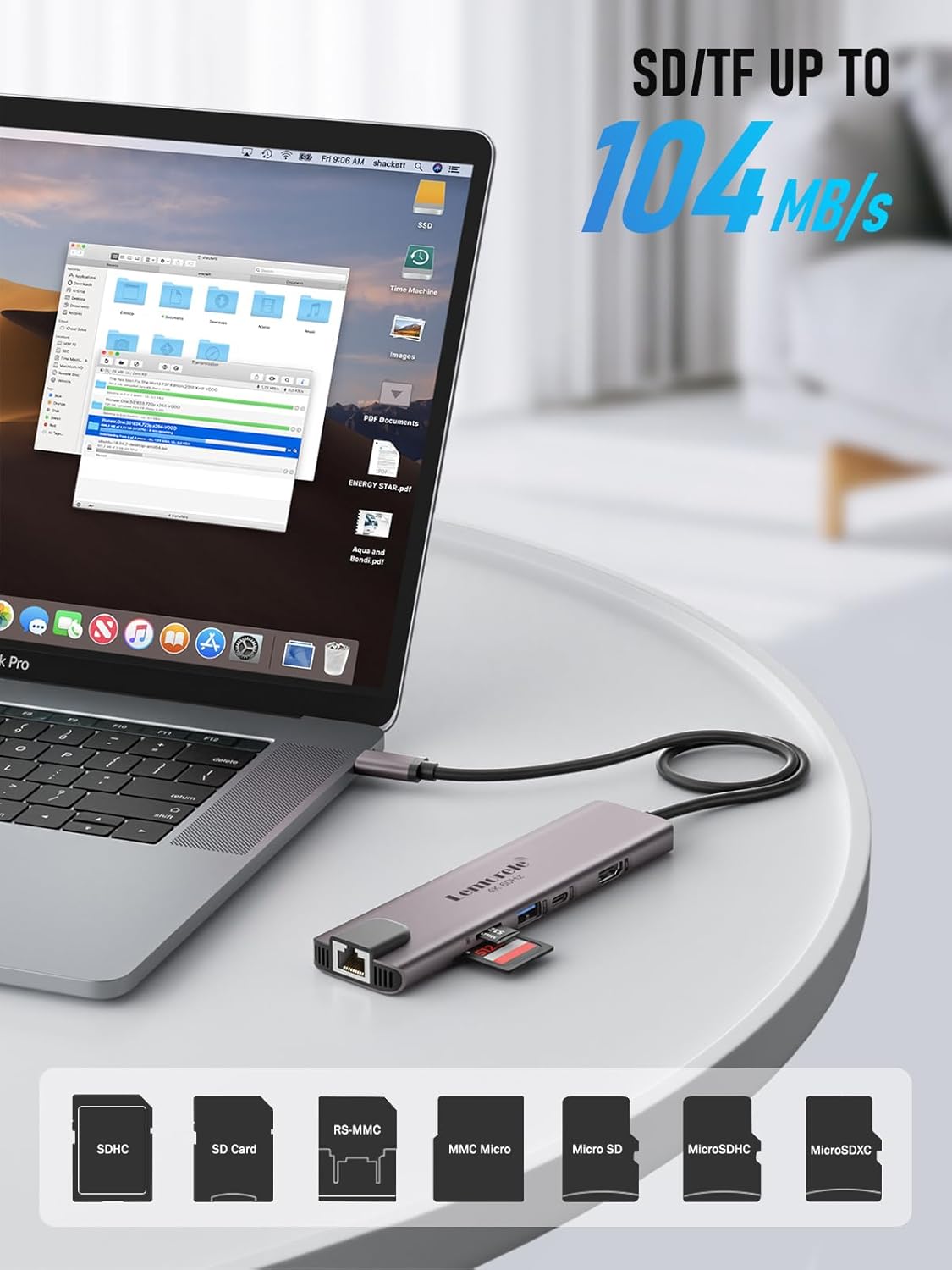 Laptop with USB-C hub attached, displaying file management software, on a white surface.