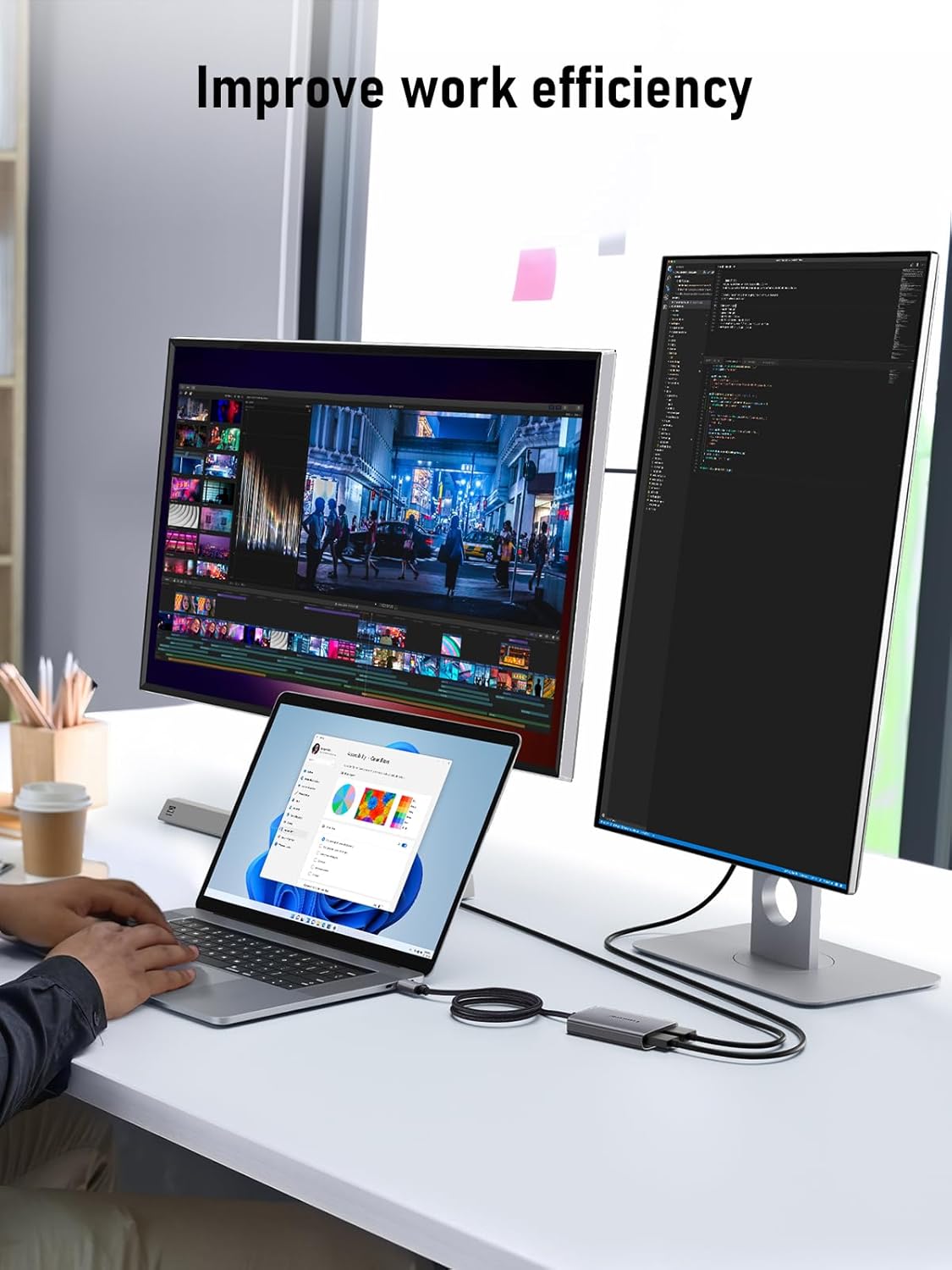 Person working at a desk with three computer monitors displaying different applications.