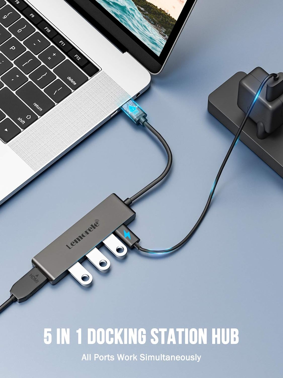 5-in-1 docking station hub connected to a laptop on a blue surface