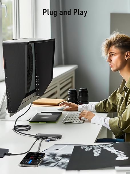 Person using a computer setup with multiple devices on a desk, featuring 'Plug and Play' text.